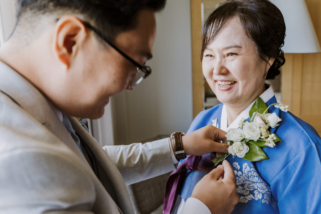 groom putting on mom's corsage