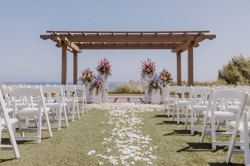 catalina point wedding lawn at terranea resort, rose petals and flower columns at the alter