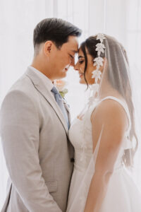bride and groom backlit in front of the window at terranea resort room.  One of the best south bay wedding venues..
